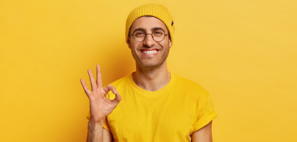 portrait-handsome-young-man-makes-okay-gesture-demonstrates-agreement-likes-idea-smiles-happily-wears-optical-glasses-yellow-hat-t-shirt-models-indoor-its-fine-thank-you-hand-sign