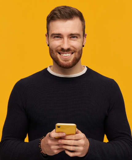 portrait-positive-male-with-brunette-hair-bristle-has-piercing-wearing-black-sweater-holding-mobile-phone-copy-space-right-isolated-yellow-wall
